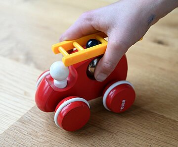 Kind spielt mit einem Spielzeugauto.